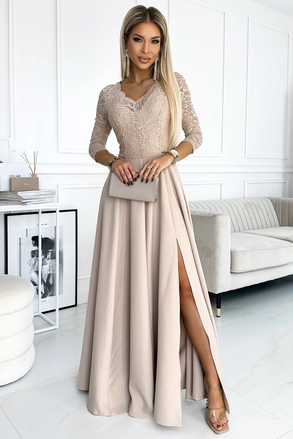 Elegantiška ilga suknelė su nėriniuotu viršumi ir trijų ketvirčių rankovėmis, subtiliai pabrėžianti moteriškumą. Suknelė turi elegantišką skeltuką, suteikiantį rafinuotumo ir judėjimo laisvės.