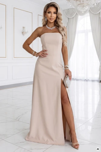 Modelis pristato šviesiai smėlinę Numoco maxi suknelę be petnešėlių su aukštu pjūviu - elegantišką vakarinę suknelę minimalistiškoje aplinkoje.}