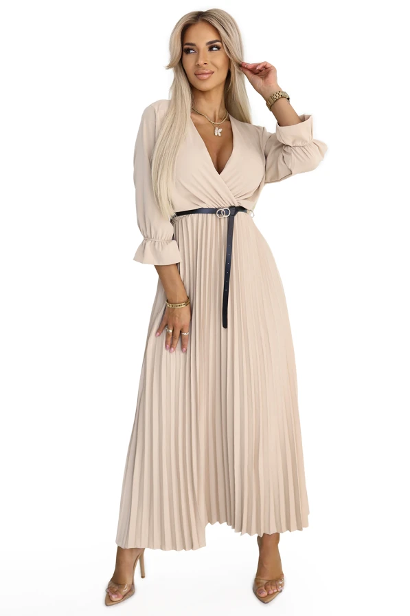 Modelka w beżowej plisowanej sukience maxi z kopertowym dekoltem i paskiem w talii – idealna na wesele, chrzciny, przyjęcia rodzinne, do pracy lub na elegancką kolację.