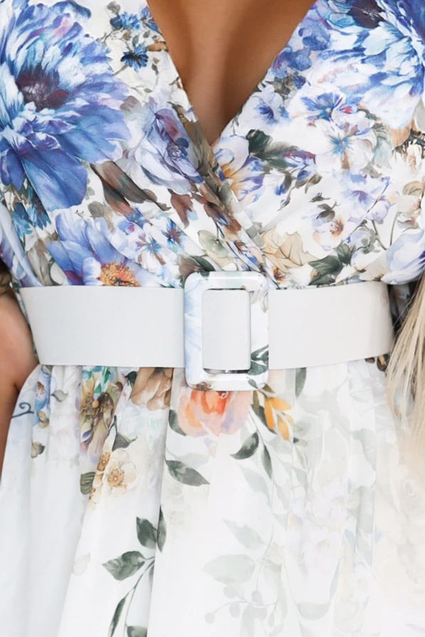 Modelka prezentuje długą błękitną sukienkę maxi marki Numoco Basic, ozdobioną romantycznym kwiatowym ombre i kopertowym dekoltem. Stylizacja idealna na lato, podkreśla kobiecą sylwetkę i lekkość materiału – perfekcyjna na wyjątkowe okazje.